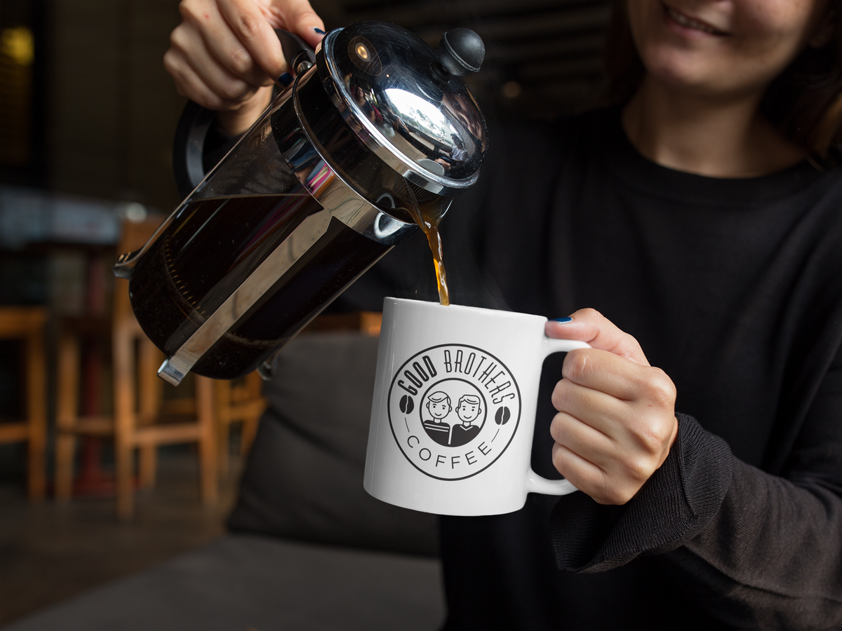 Woman pouring roasted Good Brothers Coffee LLC. Roaster's Choice coffee into a mug, showcasing the coffee's rich aroma and inviting presentation.