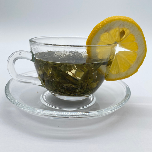 Citron Green Loose Leaf Tea by Novel Tea Book Shop, vibrant green tea leaves in a clear glass jar.