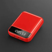 Red portable power bank with 30000mAh capacity and LED digital display on black background