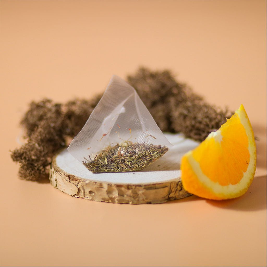 Orange Sugarbird herbal tea by Birdsong Tea featuring vibrant orange and green rooibos tea leaves in a natural setting.