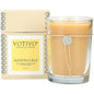 Votivo Honeysuckle Aromatic Candle in a 6.8oz glass jar with floral label, emitting a soft glow and floral scent.