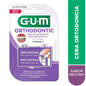 GUM Ortho Orthodontic Wax for braces, shown next to assorted candies and chocolates on a white background.