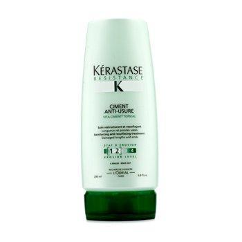 Kerastase Resistance Ciment Anti-Usure treatment bottle for damaged hair lengths, 200ml, on a wooden end table.