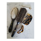 Hand-crafted Italian paddle hair brush by Pasteur Pharmacy with wooden handle and wide brushing surface.