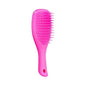 Hot pink Tangle Teezer mini hairbrush for detangling, featuring a compact design and ergonomic handle for easy styling.