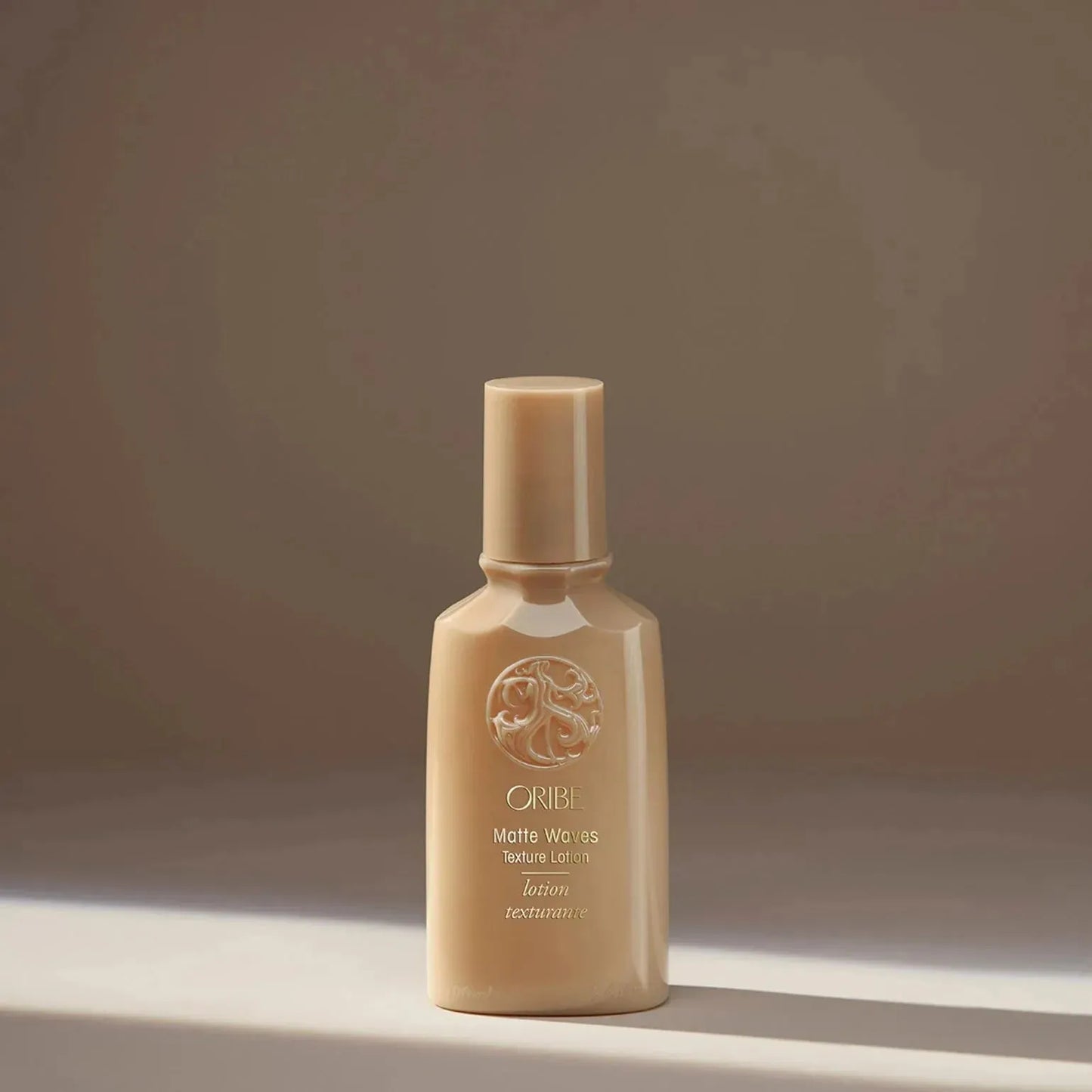 Oribe Matte Waves Texture Lotion 100ml, a hair lotion for tousled, matte-finish waves, shown in a sleek bottle.