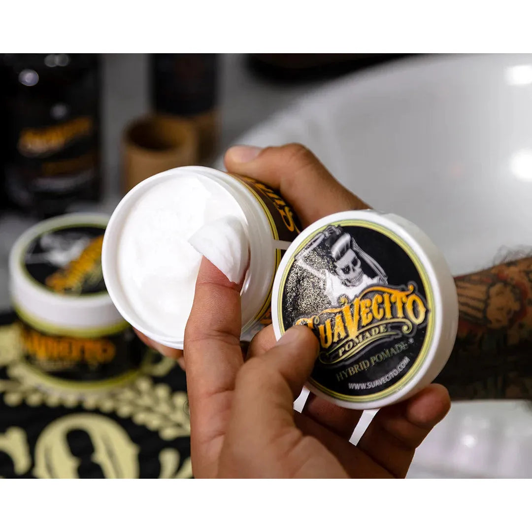 Suavecito Pomade Hybrid 4oz hair pomade in a jar, used for styling and holding hair with a smooth, glossy finish.