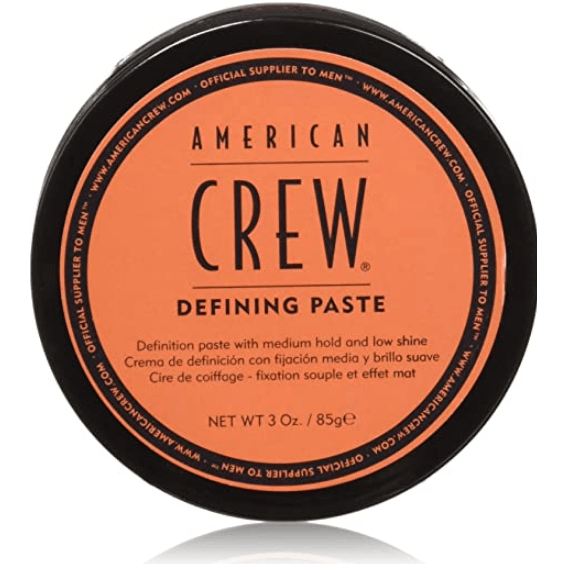 American Crew Defining Paste hair styling paste in 3 oz jar, with a natural, textured appearance and a black lid.