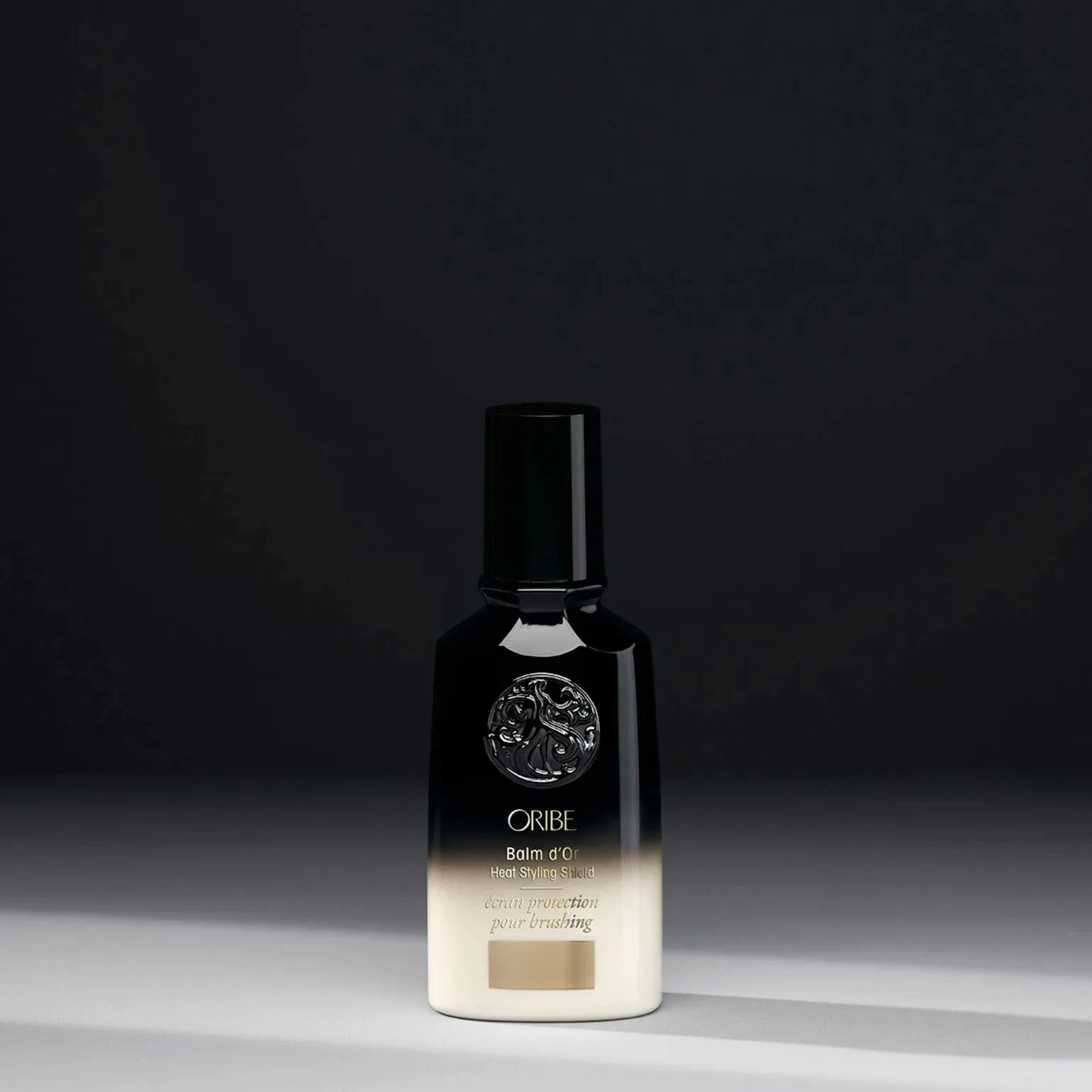 Oribe Balm d'Or Heat Styling Shield 100ml bottle, protective spray for heat styling, with sleek design and pump nozzle.