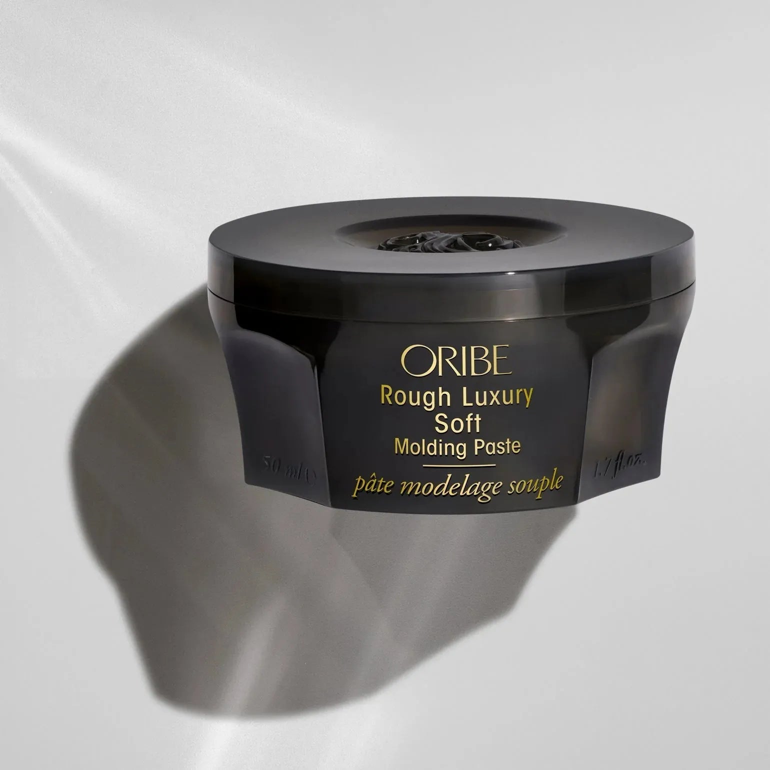 Oribe Rough Luxury Soft Molding Paste in 50ml jar, styling product with a sleek black container and white lid for textured hair styling.