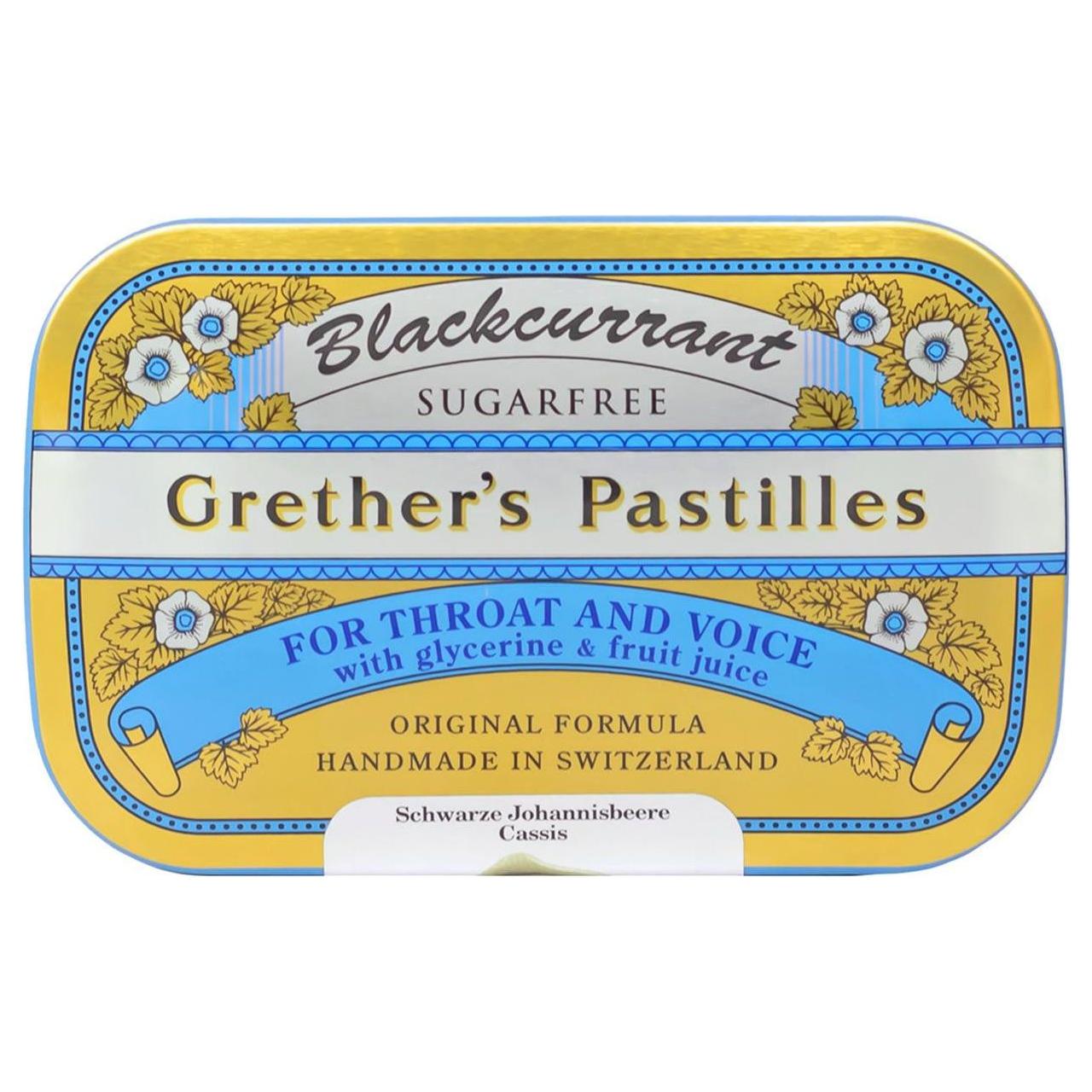Black currant flavored sugarfree pastilles by Grether's in a 15 oz package, displayed in a clear container with a natural setting.