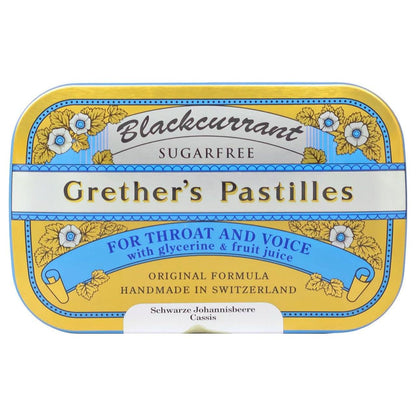 Black currant flavored sugarfree pastilles by Grether's in a 15 oz package, displayed in a clear container with a natural setting.