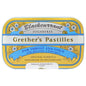 Black currant flavored sugarfree pastilles by Grether's in a 15 oz package, displayed in a clear container with a natural setting.