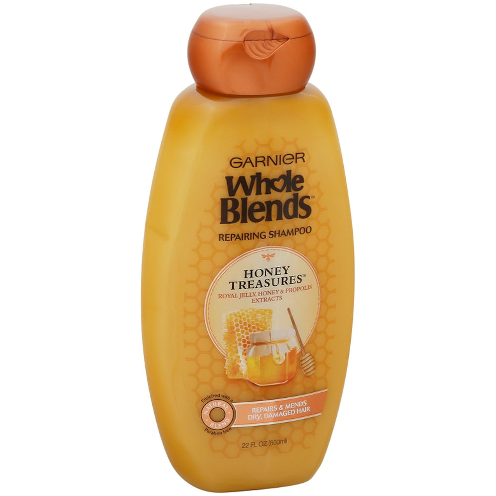 Garnier Whole Blends Honey Treasures Shampoo for damaged hair in a 650 mL bottle, featuring natural honey ingredients.