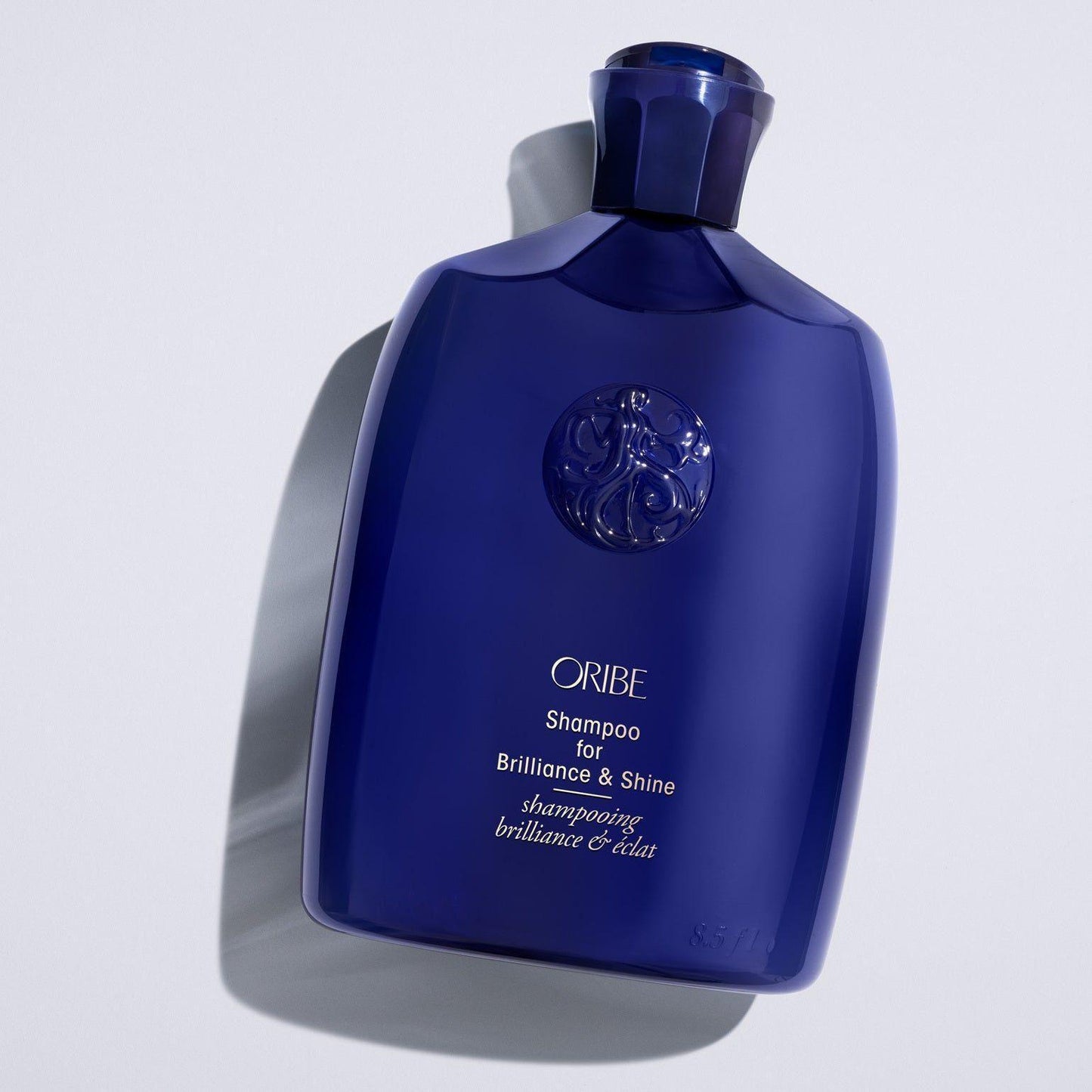 Oribe shampoo for brilliance and shine in a 250 ml bottle, featuring a sleek design and clear labeling.