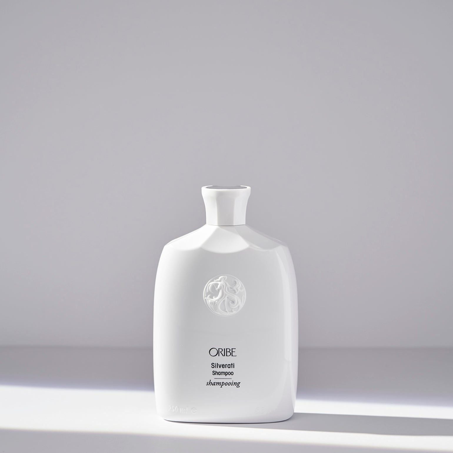Oribe Silverati Shampoo 250 ml bottle, featuring sleek packaging and product label for maintaining silver hair shine and color.