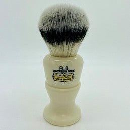 Simpson Polo Pl8 Sovereign synthetic fibre shaving brush with white handle and dense bristles, used for lathering shaving soap.