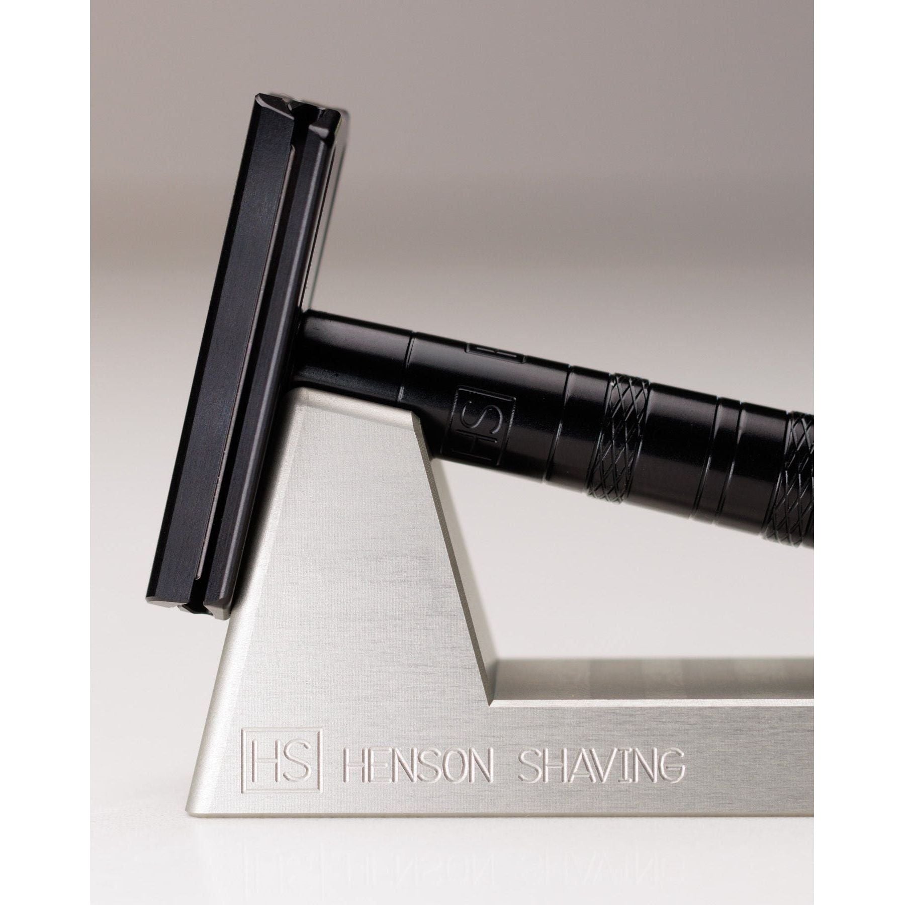 Pasteur Pharmacy Henson Shaving Razor Stand holding a razor, designed to hold and display a shaving razor securely.