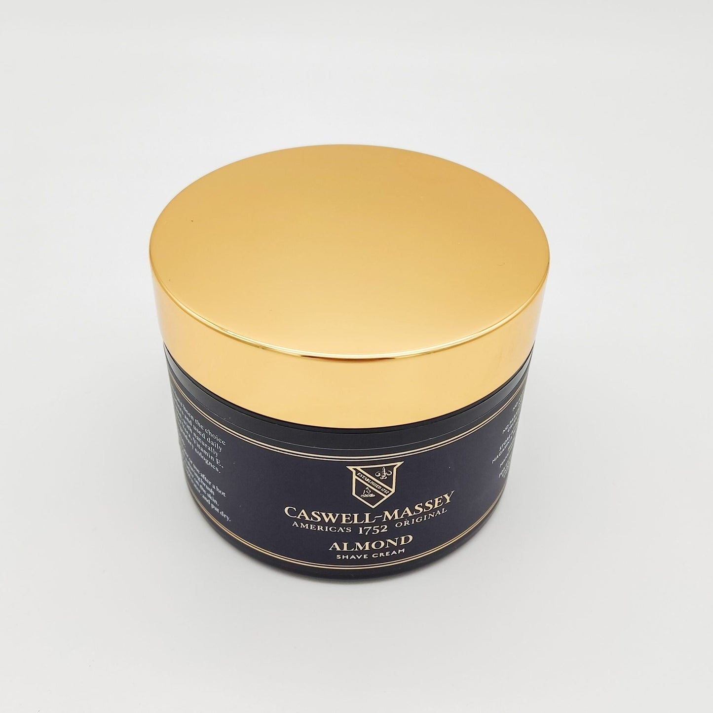 Caswell-Massey Almond Shave Soap and Cream collection with a 5.2 oz shaving soap and cream, displayed in a natural setting.