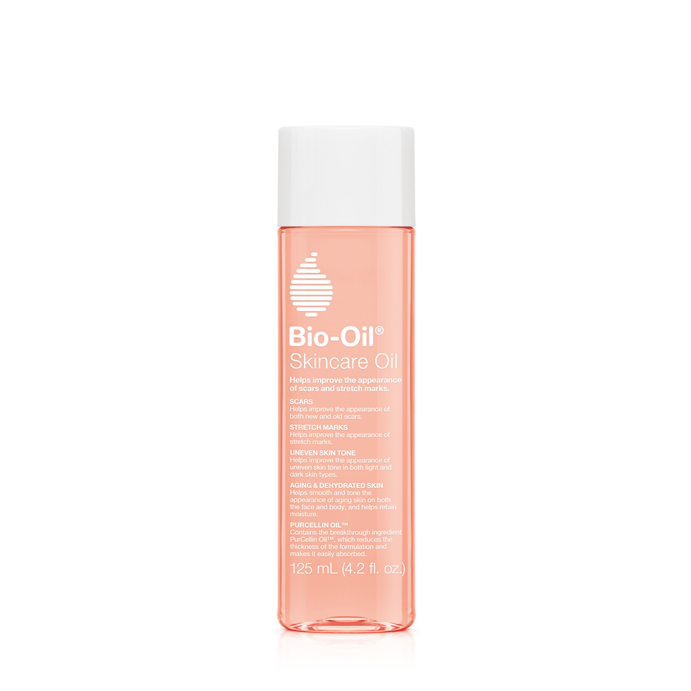 Bio-Oil skincare bottle with Vitamin A and E for all skin types, shown in a natural setting, highlighting skincare benefits.