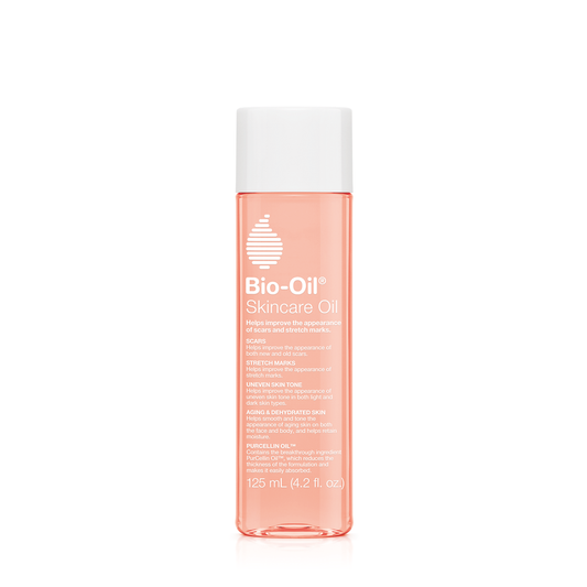Bio-Oil skincare bottle with Vitamin A and E for all skin types, shown in a natural setting, highlighting skincare benefits.