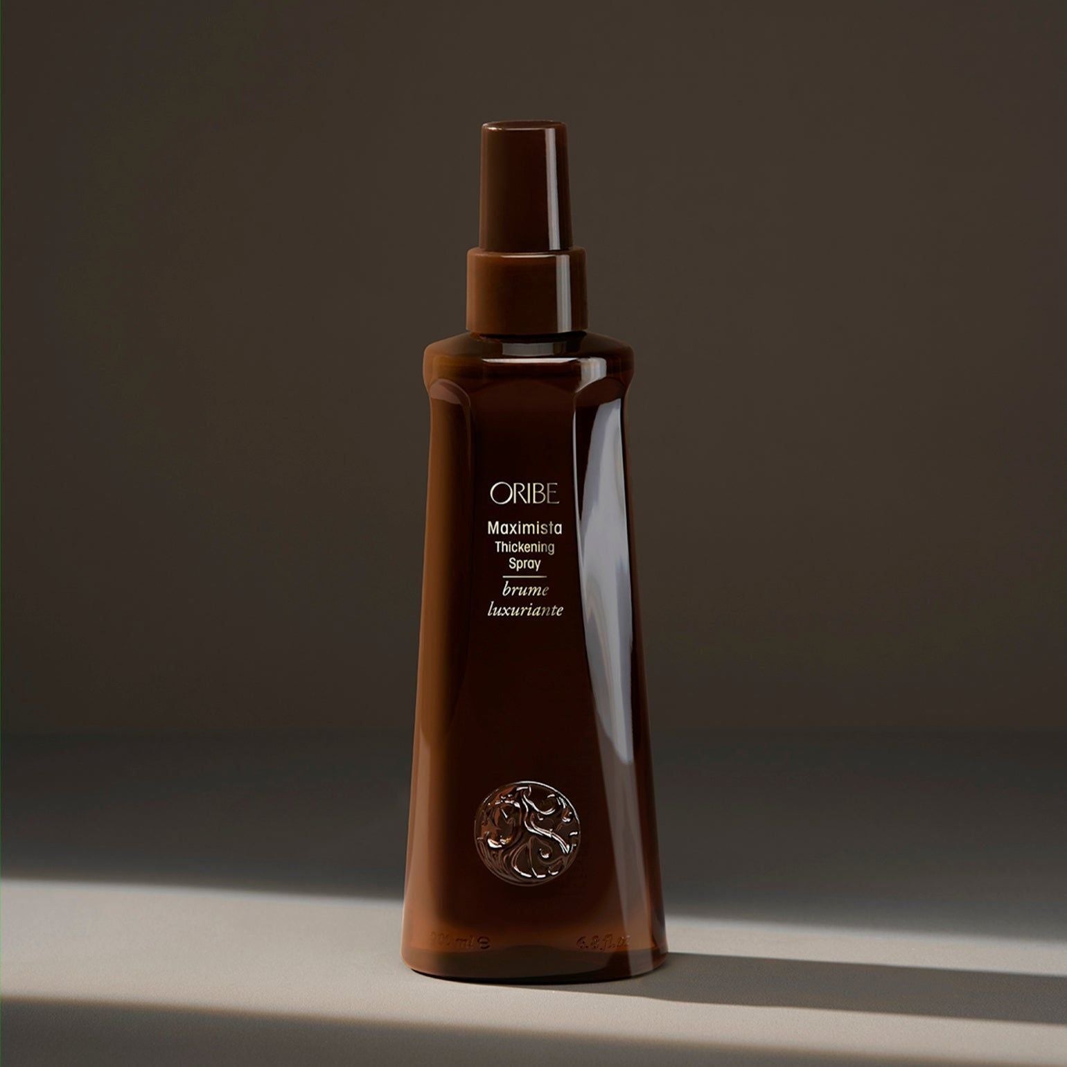 Oribe Maximista Thickening Spray in 200 ml bottle, designed to add volume and body to hair.