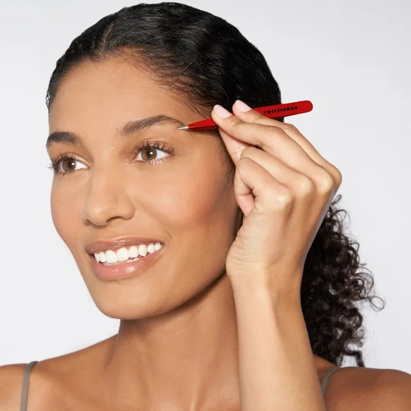 Red Tweezerman Point Tweezers for precise hair plucking and grooming, shown with pointed tips for detailed tweezer work.