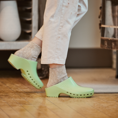 Calzuro Classic clogs in pistachio green with a smooth, hole-free design, ideal for medical or professional use.