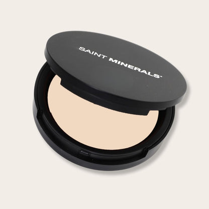Warm-toned pressed powder foundation by Saint Minerals from Panoply Beauty, showing the compact and textured powder surface.