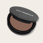 Pressed powder foundation by Panoply Beauty with warm-toned pressed powder in a compact.