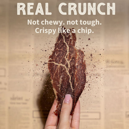 Primal Krisp 2 oz second cut brisket, showing a close-up of seasoned, cooked beef brisket slice with a smoky exterior.