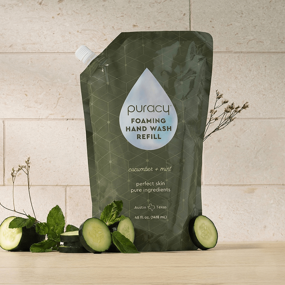 Puracy lavender vanilla foaming hand soap bottles, eco-friendly hand wash with natural scent, set of three on a bathroom sink.