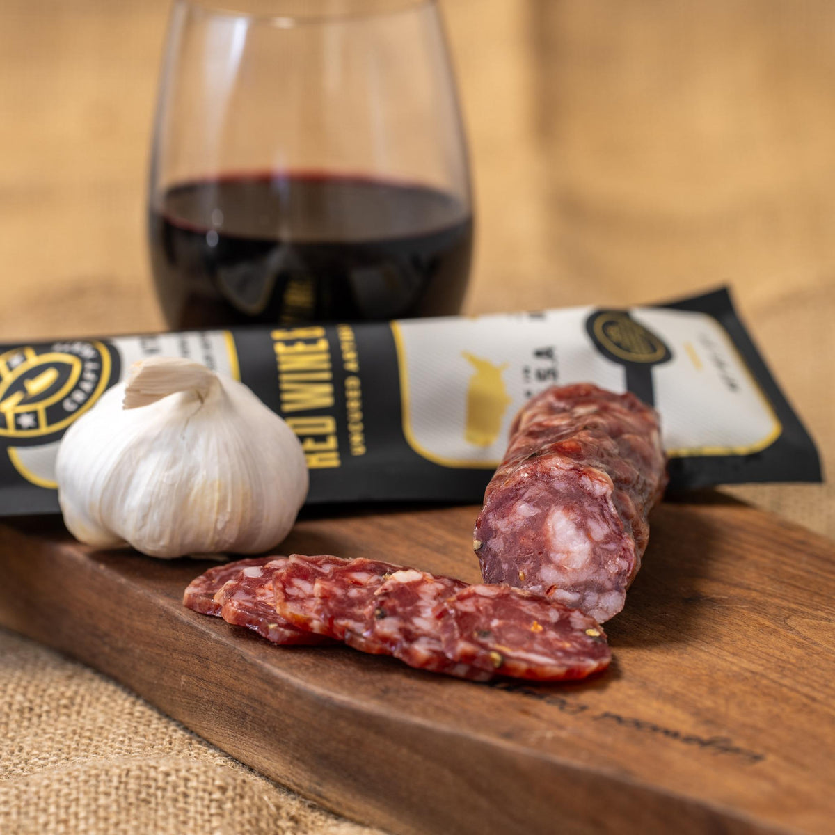 A sliced piece of red wine and garlic flavored meat from Gastros Craft Meats, showcasing marbled red meat with garlic seasoning.