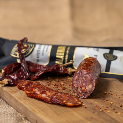 Spicy Calabrian chili peppers from Gastros Craft Meats in a jar, showcasing vibrant red chili peppers ready for cooking or garnishing.
