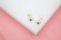 Rhodium-plated 18K gold filled tiny ball stud earrings by MIA Jewelry on a white background.