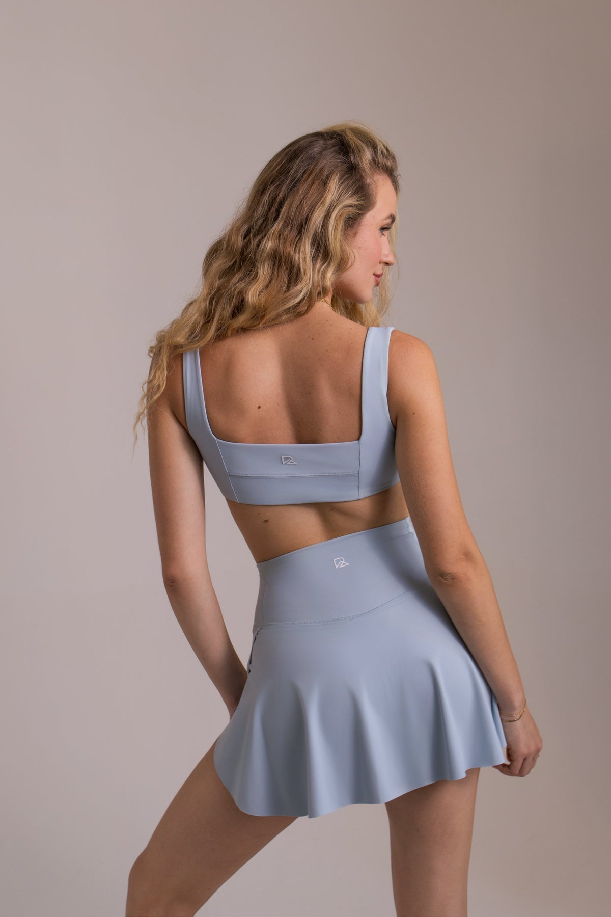 Women's athletic skort with built-in shorts and pockets in baby blue, LuxeForm criss-cross waist, from Runner's Athletics.