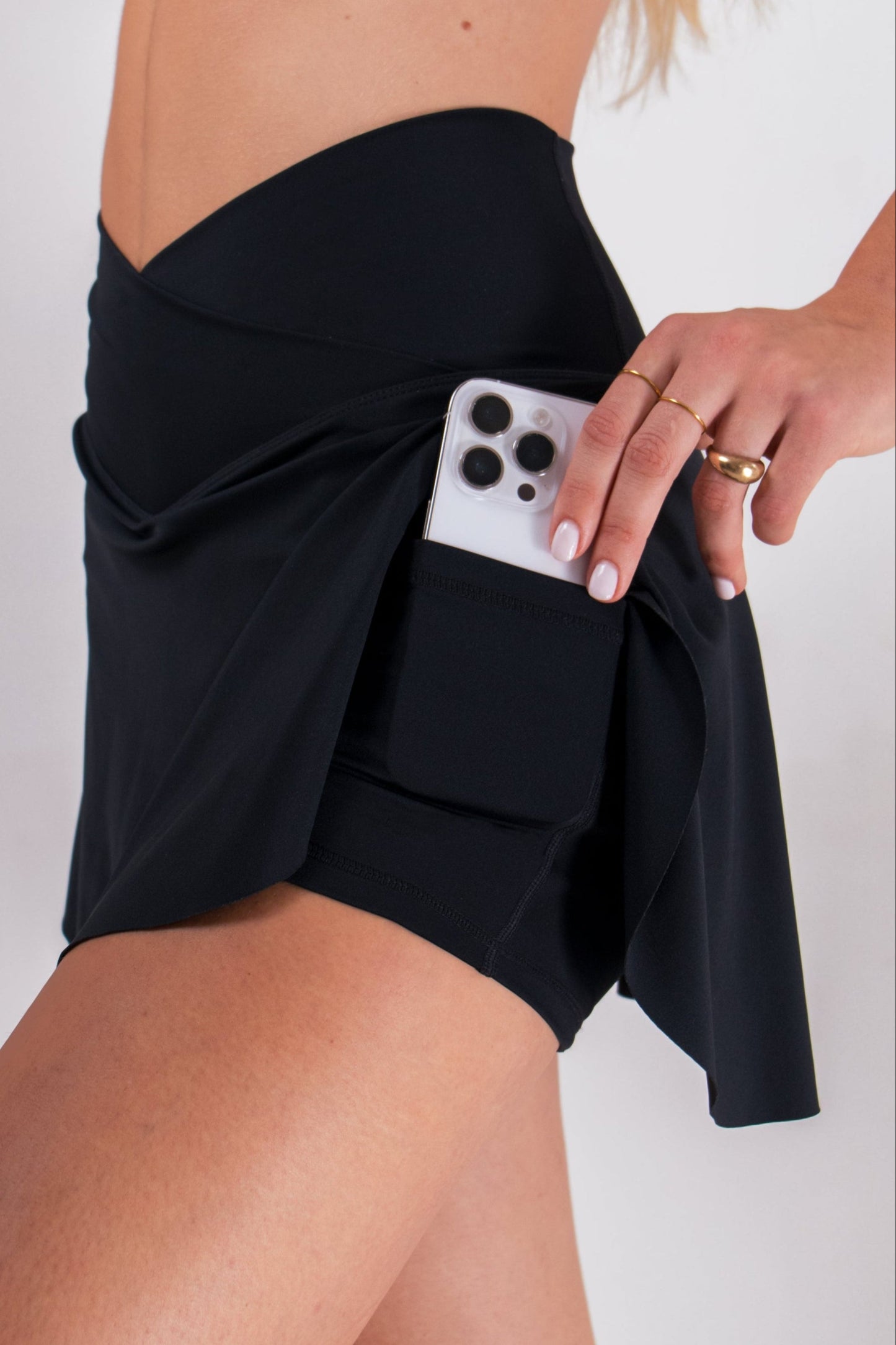 Black women's athletic skort with built-in shorts and pockets, featuring a criss-cross waistband by Runner's Athletics.