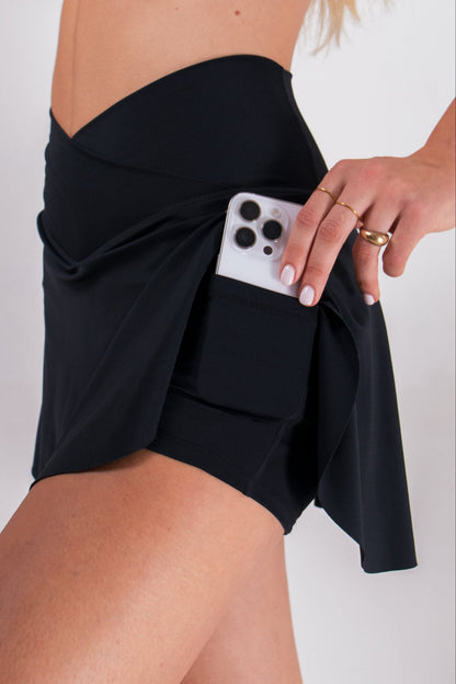 Black women's athletic skort with built-in shorts and pockets, featuring a criss-cross waistband by Runner's Athletics.
