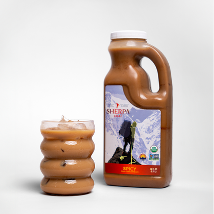 Bottle of Sherpa Chai Nepal Tea chai concentrate beverage with a dark liquid inside and label on the front.