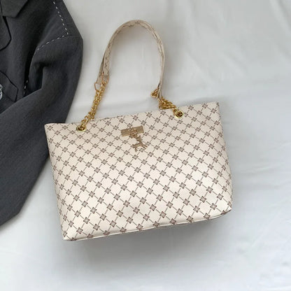 Luxury women's crossbody handbag in white leather with textured finish, large capacity tote with hanging accessories and shoulder strap.