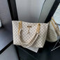 Luxury women's crossbody handbag in white with soft leather texture, large capacity tote featuring hanging accessories and shoulder strap.