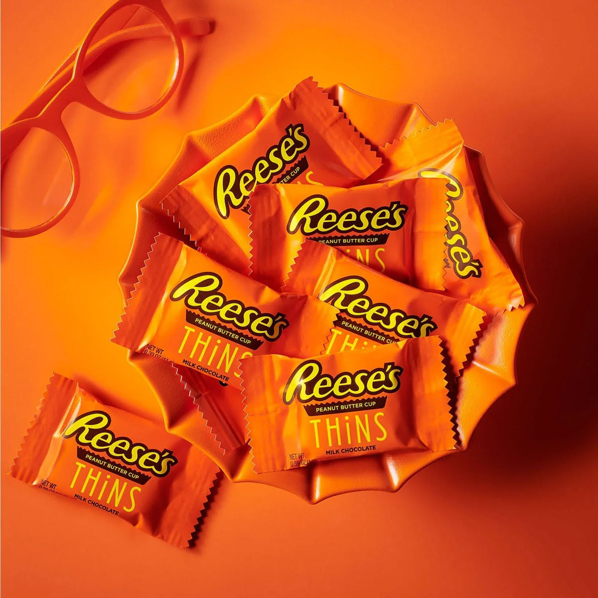 Reese's Peanut Butter Cup Thins Milk Chocolate candy in a package, showcasing the thin chocolate coating and peanut butter filling.