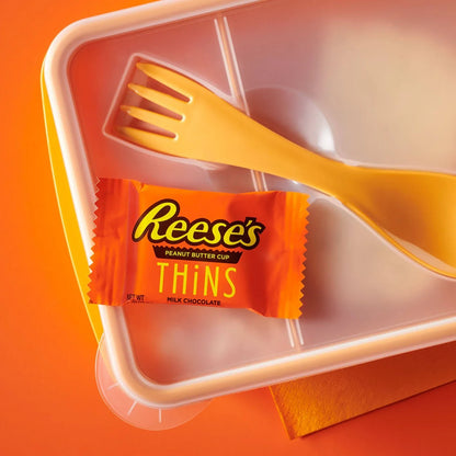 Reese's Peanut Butter Cup Thins Milk Chocolate candy in a clear bag, showcasing thin chocolate cups with peanut butter filling.