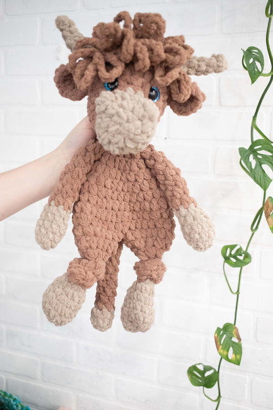 Crochet Highland Cow stuffed animal, a cozy Highland Cow lovey and snuggler by The McGarvey Workshop, perfect for cuddling.
