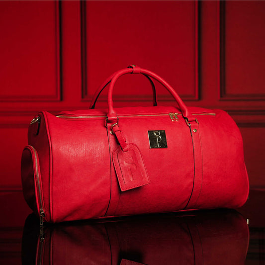 Red tumbled leather weekender duffle bag by Sole Premise, featuring sturdy handles and spacious interior for travel.
