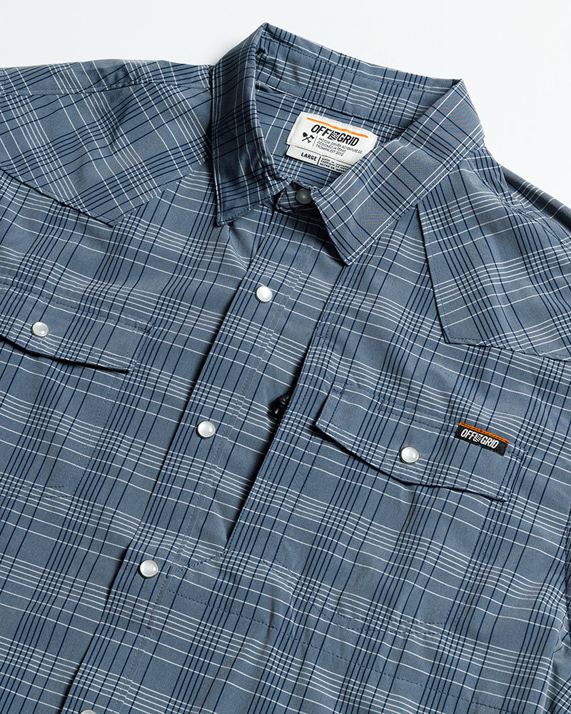 Short sleeve Deke SS Shirt in Dusty Royal by Off The Grid Surplus, featuring a button-up design and blue fabric.