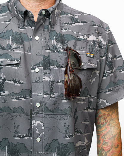Dark grey San Saba SS Shirt by Off The Grid Surplus, short sleeve button-up style, displayed on a hanger.