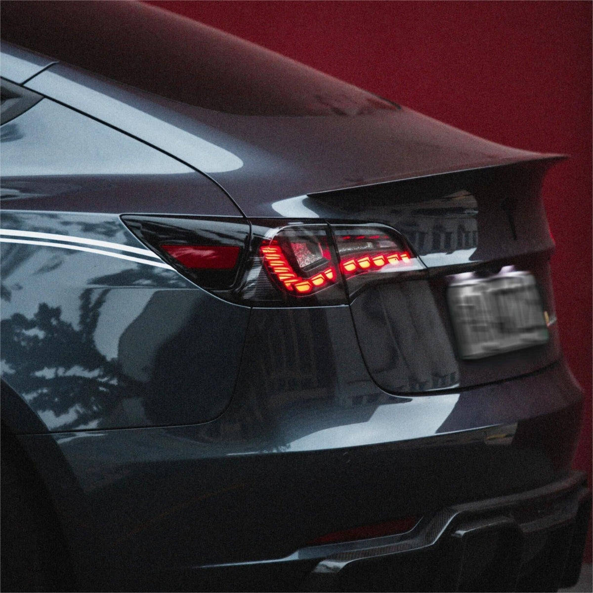 Tesla Model 3/Y Dragon Scale Tail Lights by Tesery, showcasing sleek, dragon-scale design and bright red tail light illumination.