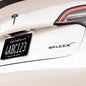 Black ABS SpaceX logo emblem for Tesla rear trunk, vehicle accessory with SpaceX branding and sleek black design.