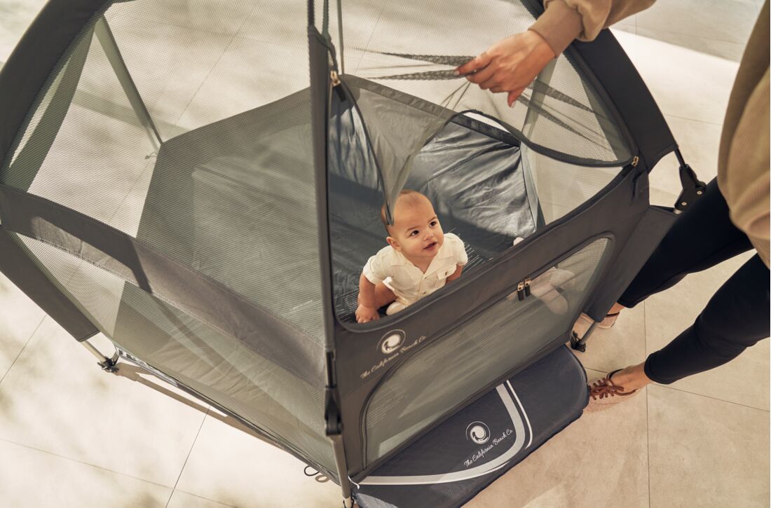 Pop 'N Go Playpen in cosmic gray by The California Beach Company LLC, showing a portable playpen with mesh sides and sturdy frame.